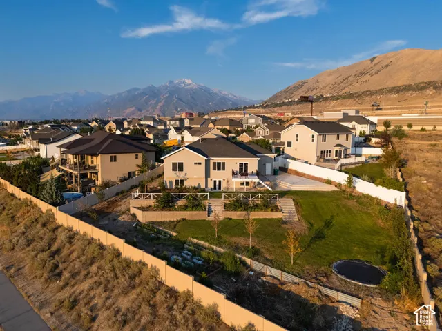 Contemporary-style residence with a tiered backyard, featuring a manicured lawn, concrete patio, and a privacy fence