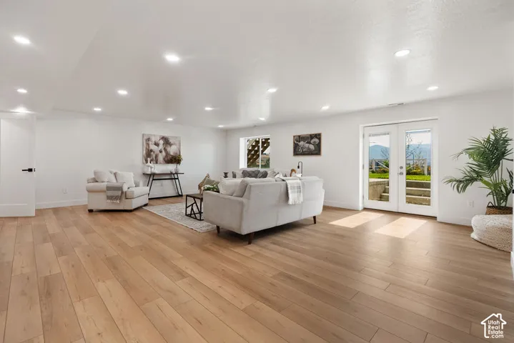 Expansive room featuring wood-finish flooring, recessed lighting, and white walls