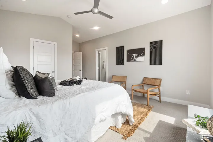 Bright primary bedroom with recessed ceiling lighting and ceiling fan, neutral wall finishes, engineered wood-finish flooring, and abundant natural light from multiple windows