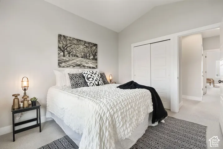 Serene primary bedroom showcasing a quilted white bedspread, geometric patterned accent pillows, and a sepia-toned landscape artwork