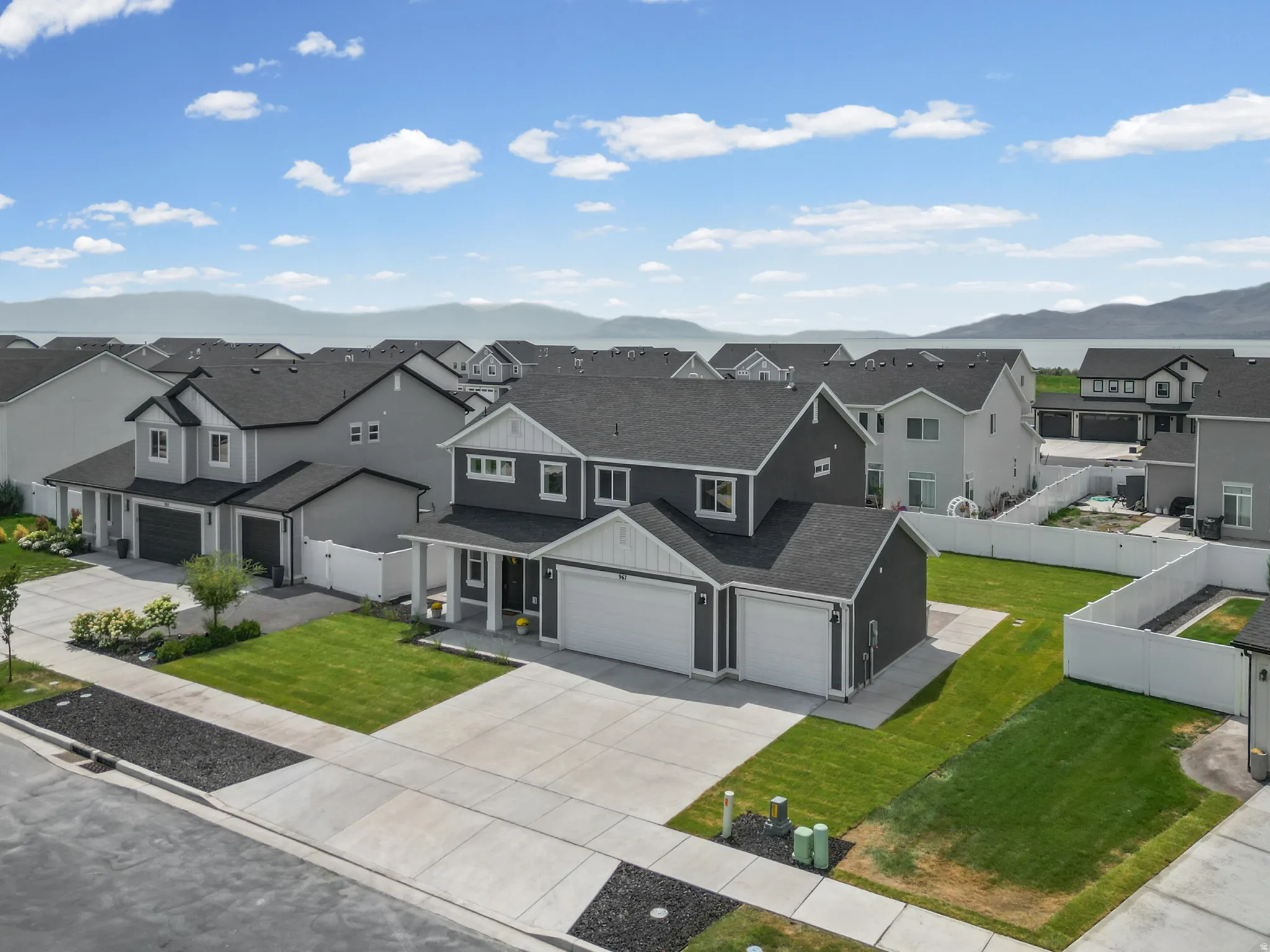 Contemporary exterior with a covered porch, attached two-car garage, and landscaped front yard