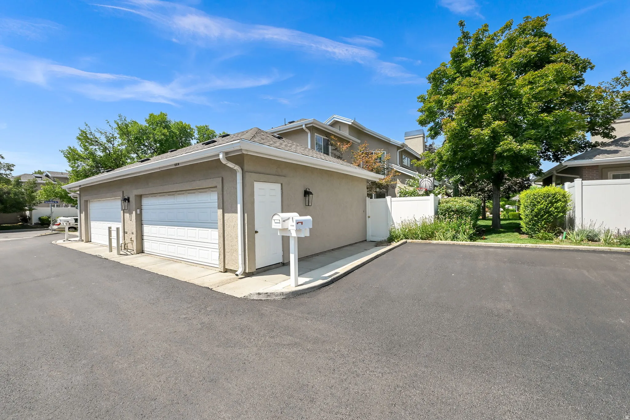 Two-car garage with panel doors, stucco exterior, and dual exterior light fixtures