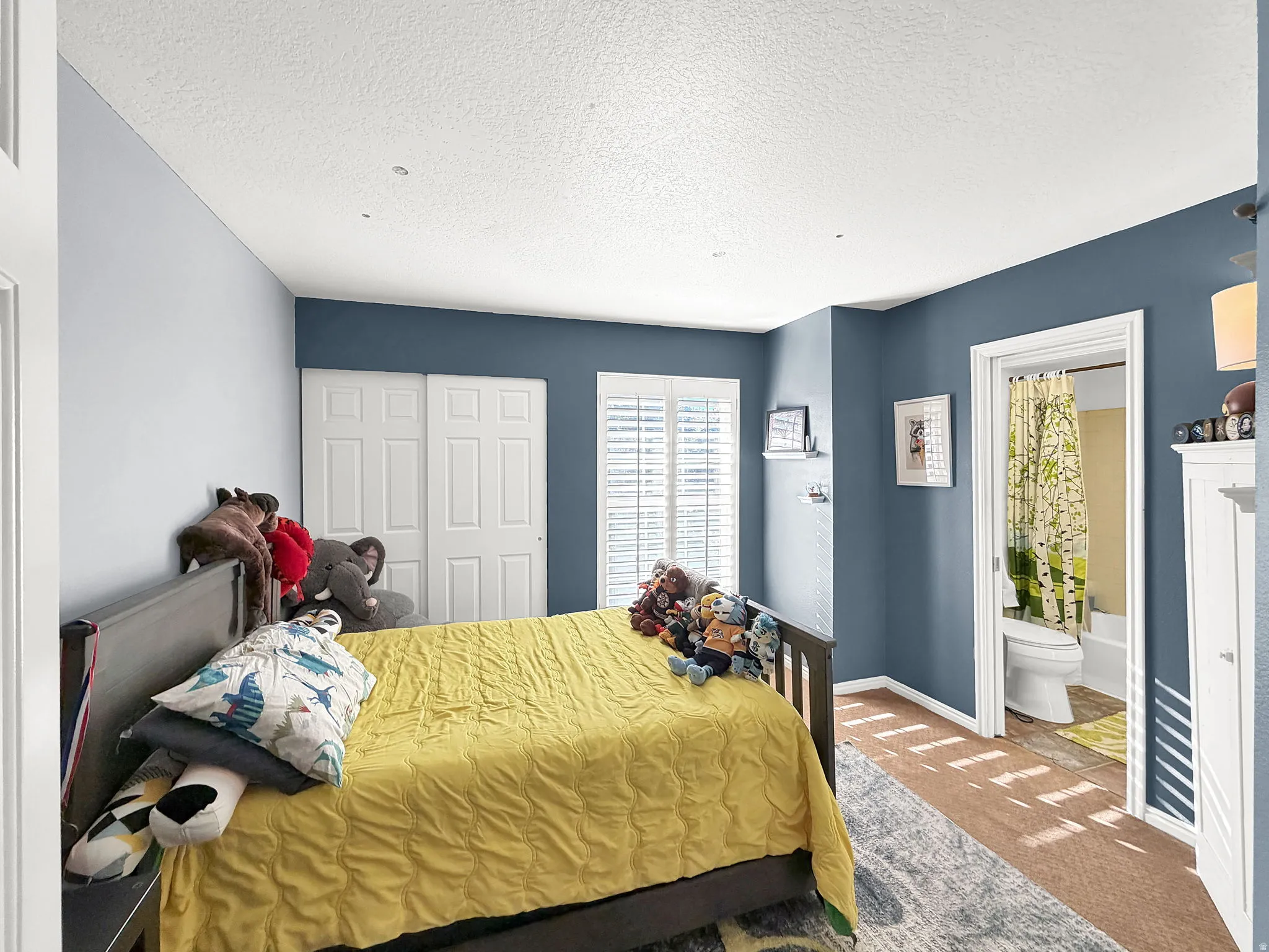 Recessed lighting, painted walls, white plantation shutters, built-in shelving, and a connected bathroom with a toilet and bathtub