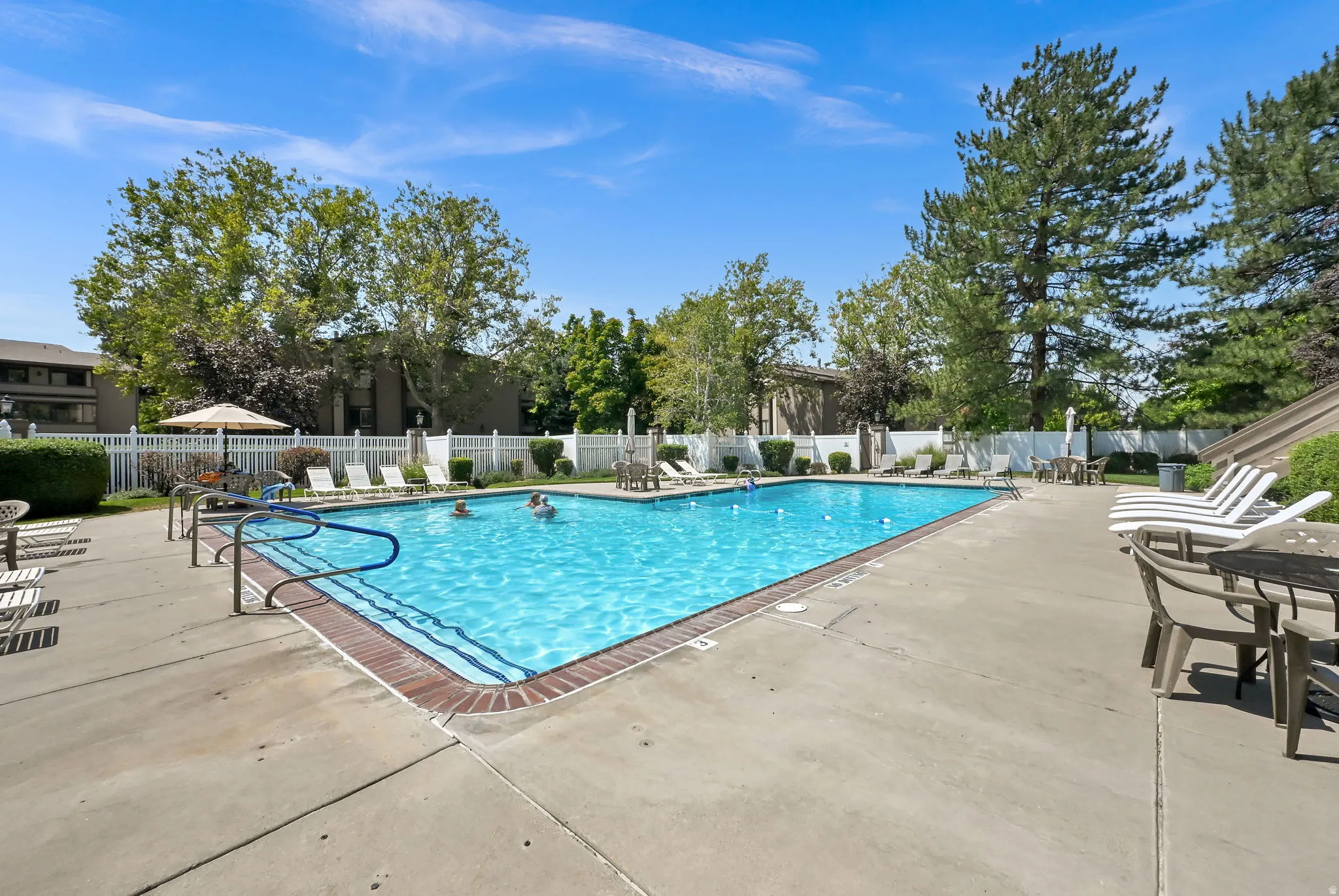 Rectangular swimming pool with blue water and surrounding concrete decking
