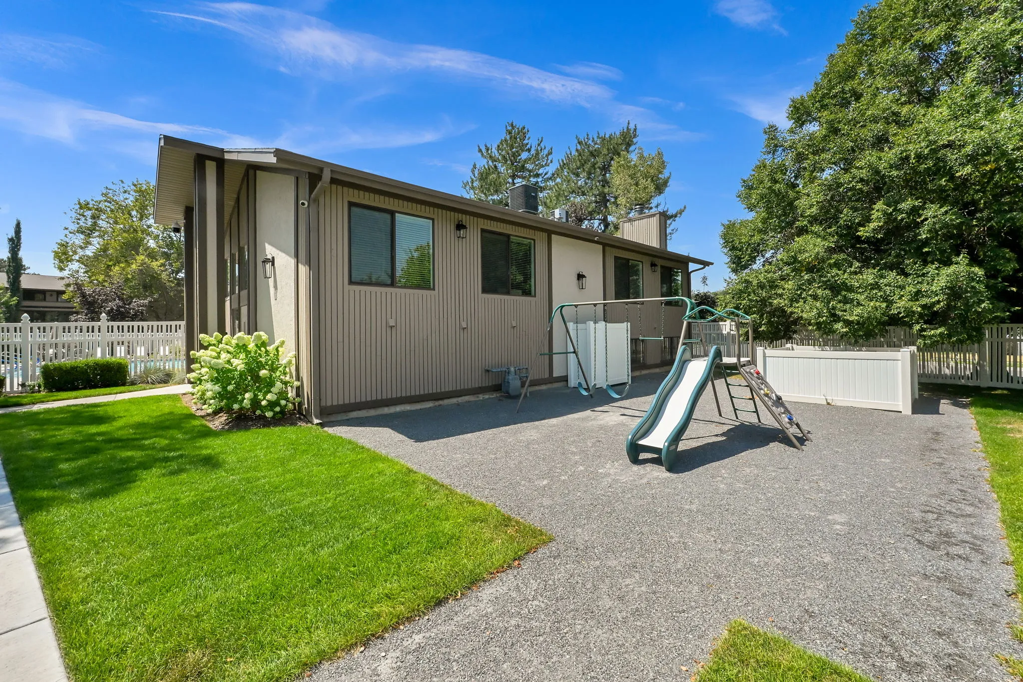 Exterior featuring vertical siding, multiple windows, and exterior light fixtures
