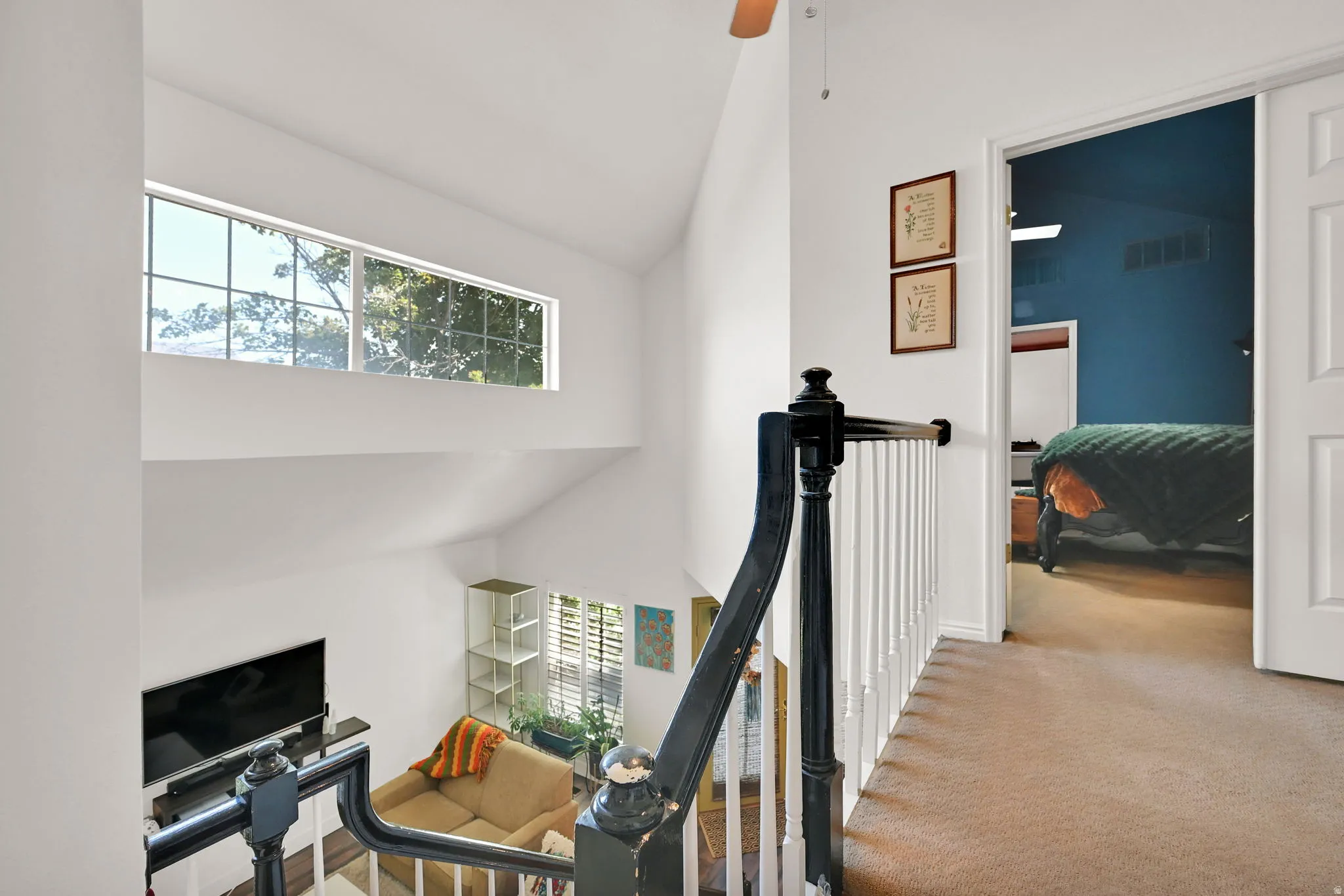 Vaulted ceilings, clerestory window, and a white balustrade with a dark wood-finish handrail
