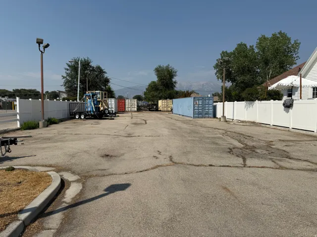 Paved lot with perimeter fencing and mountain backdrop