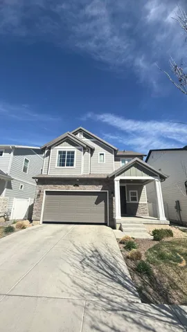 Two-story residence featuring a modern exterior with horizontal siding, gabled roofline, and stone accents