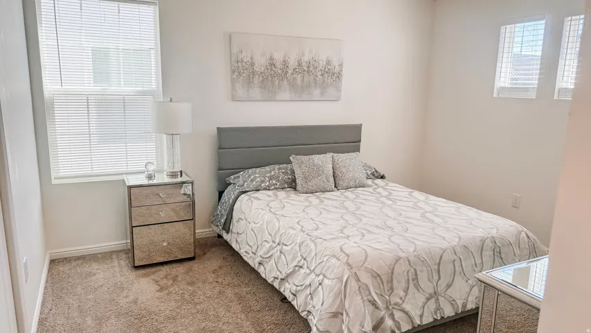 Carpeted flooring, white walls, and a window with blinds