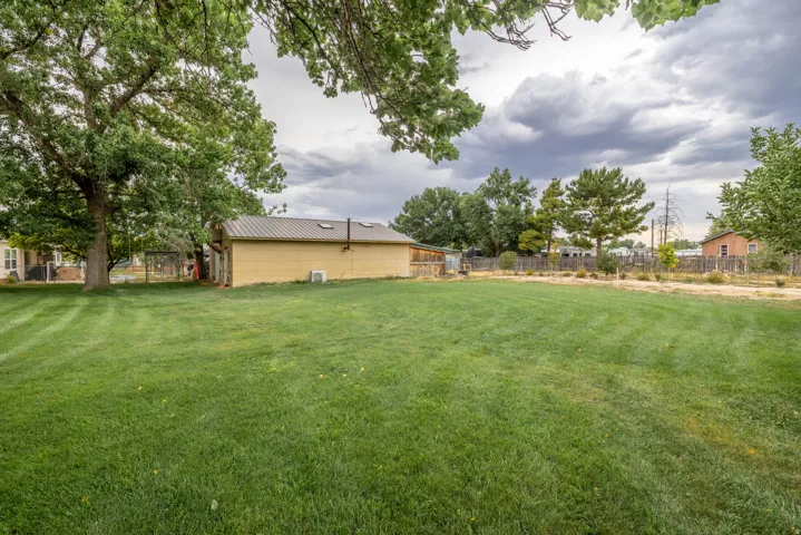 Expansive lawn area with a detached shop featuring a metal roof and light-toned siding.