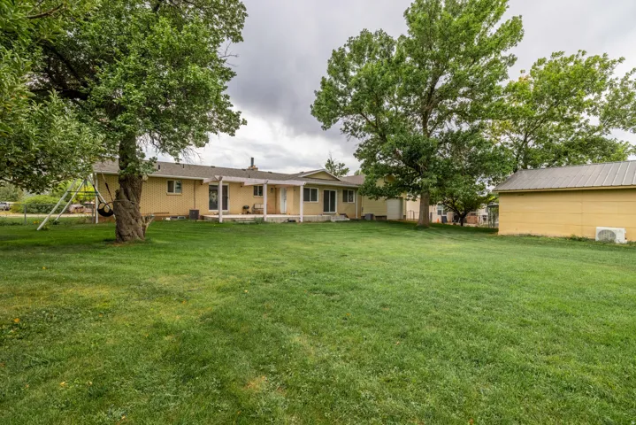 Charming brick ranch home set on expansive grounds featuring mature shade trees and a manicured lawn