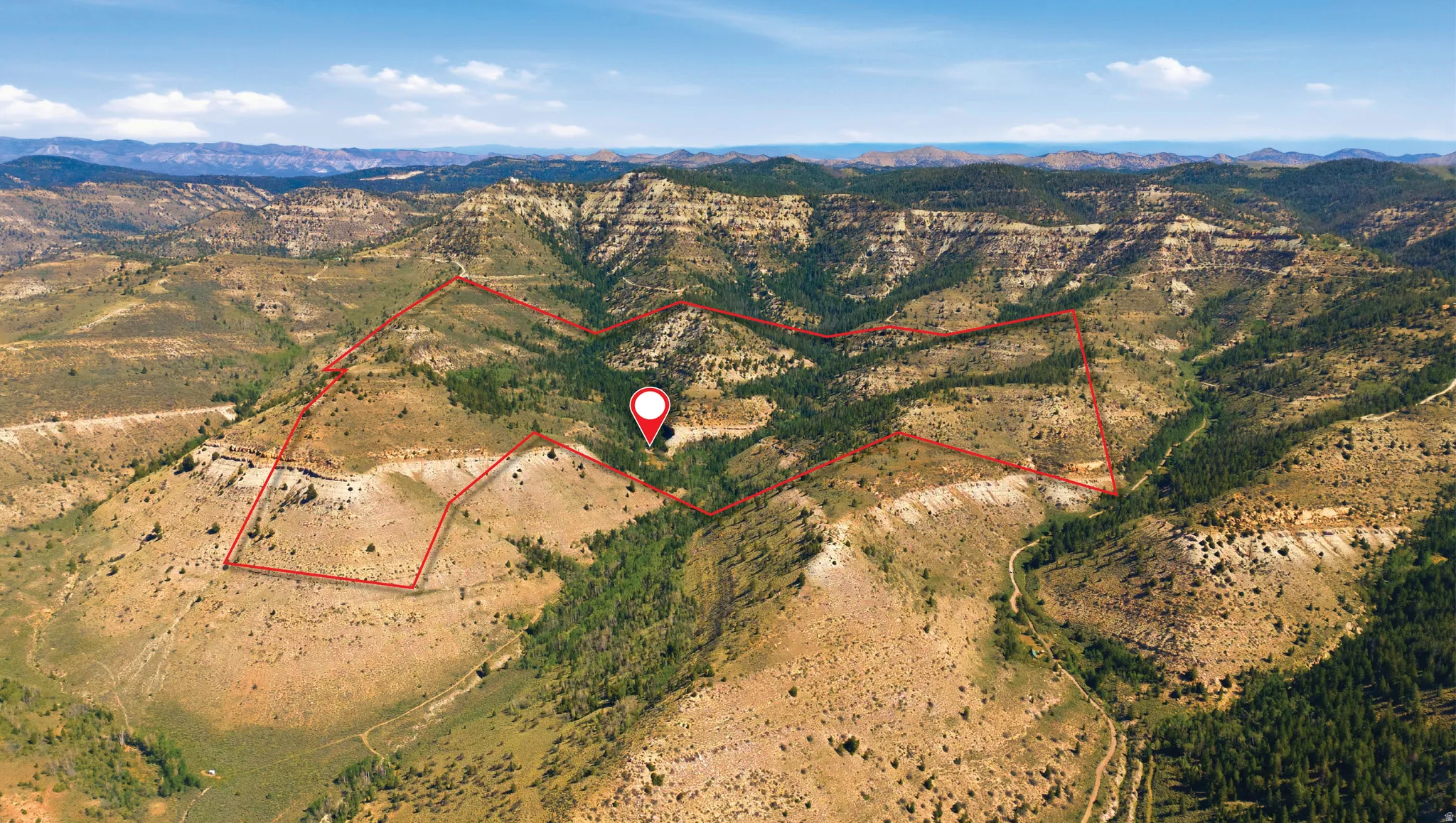 Expansive land parcel featuring diverse terrain, including rolling hills and mountainous regions