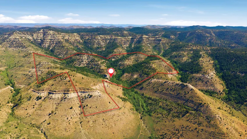 Expansive mountain terrain with varied topography, including rock formations and vegetated slopes