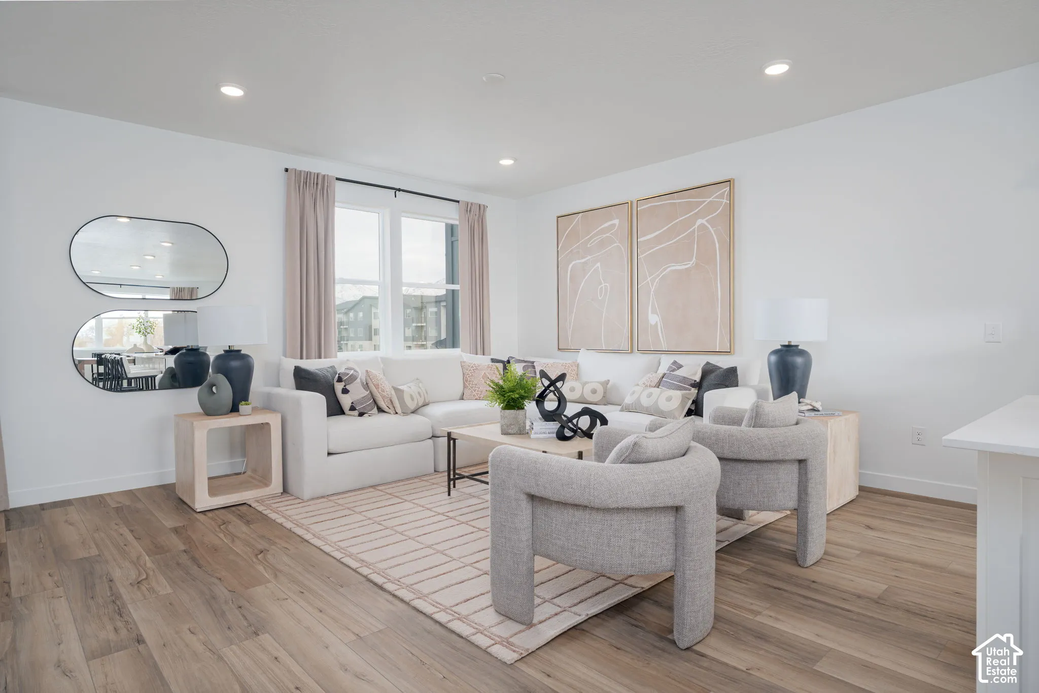 Spacious living area featuring recessed lighting, large windows, and light wood-finish flooring
