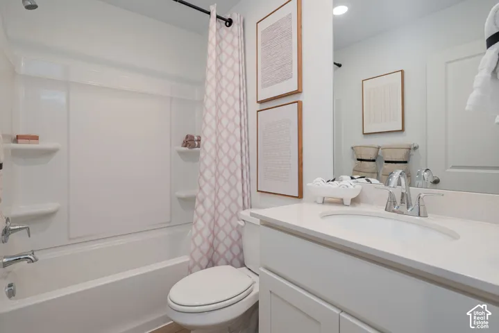 White vanity with a polished chrome faucet, under-mount sink, and light-toned countertop