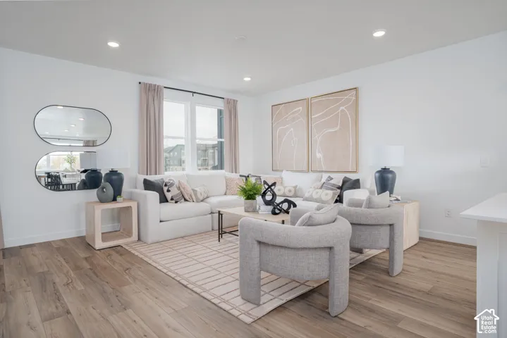 Spacious living area featuring recessed lighting, large windows, and light wood-finish flooring