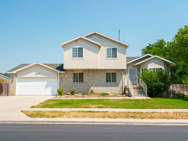 Two-story residence featuring a brick and stucco exterior, an attached two-car garage, and a concrete driveway