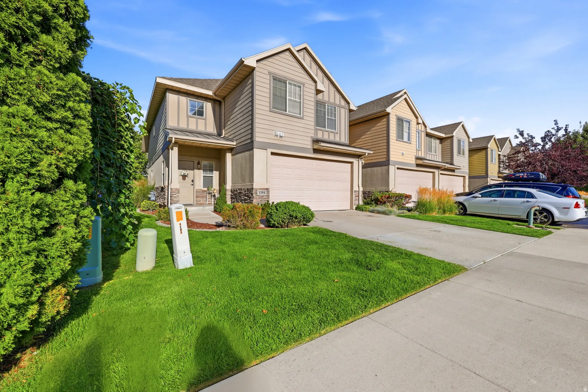 Two-story residence with a recessed entry, attached garage, and a concrete driveway