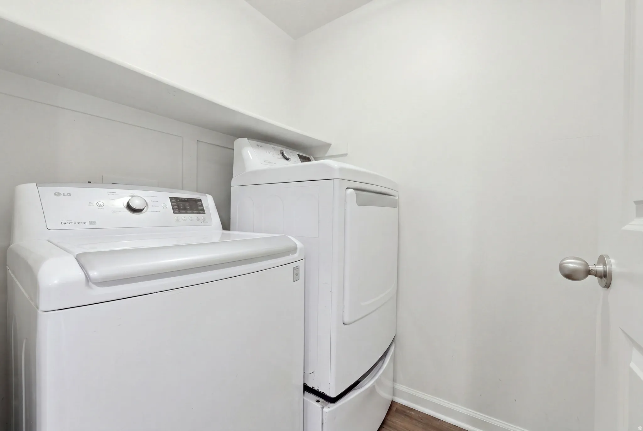 Built-in overhead shelving, wood-finish flooring, and a satin nickel door handle