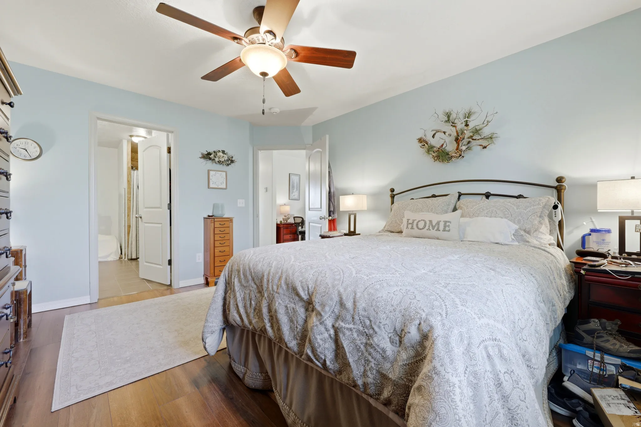 Wood-finish flooring, ceiling fan with light fixture, and arched doorways