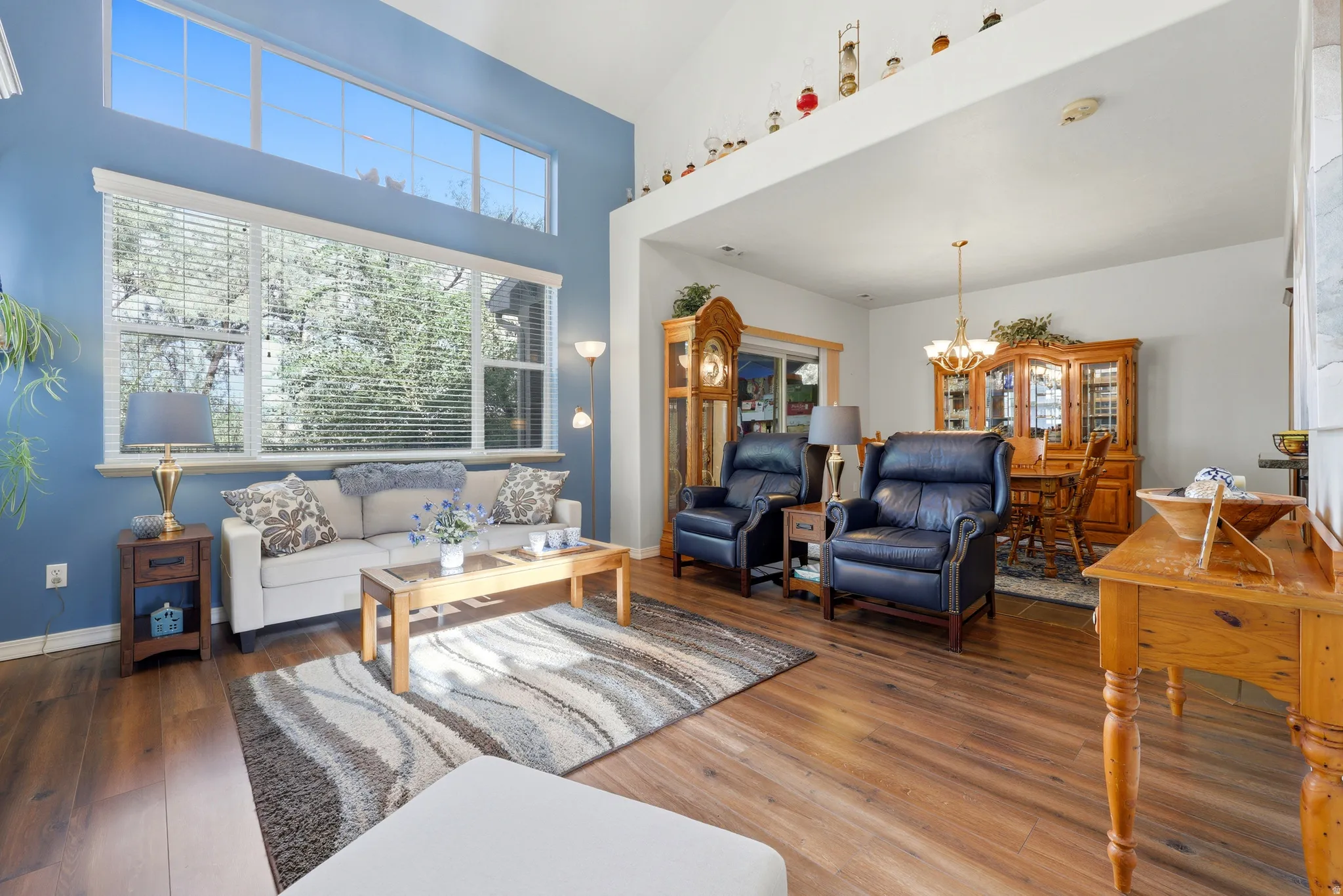 Vaulted ceiling with transom windows, wood-finish flooring, and an open layout