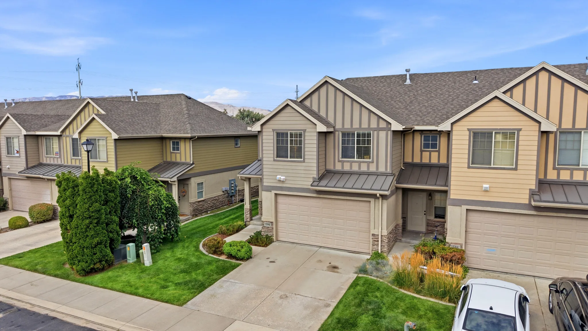 Multi-story residence featuring a two-car garage, stone and siding exterior, and a shingle roof