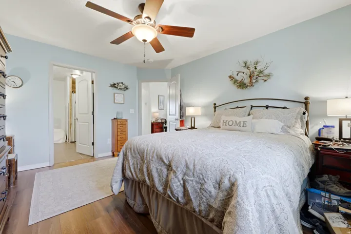 Wood-finish flooring, ceiling fan with light fixture, and arched doorways