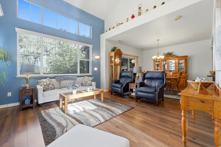 Vaulted ceiling with transom windows, wood-finish flooring, and an open layout