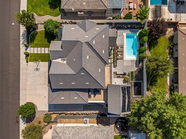 Extensive outdoor living area featuring a swimming pool, concrete patio, and a grass lawn