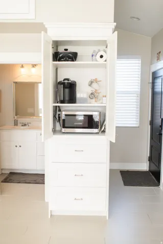 Custom built-in cabinetry with open shelving and enclosed storage, featuring a microwave nook, three drawers, and soft-close hardware