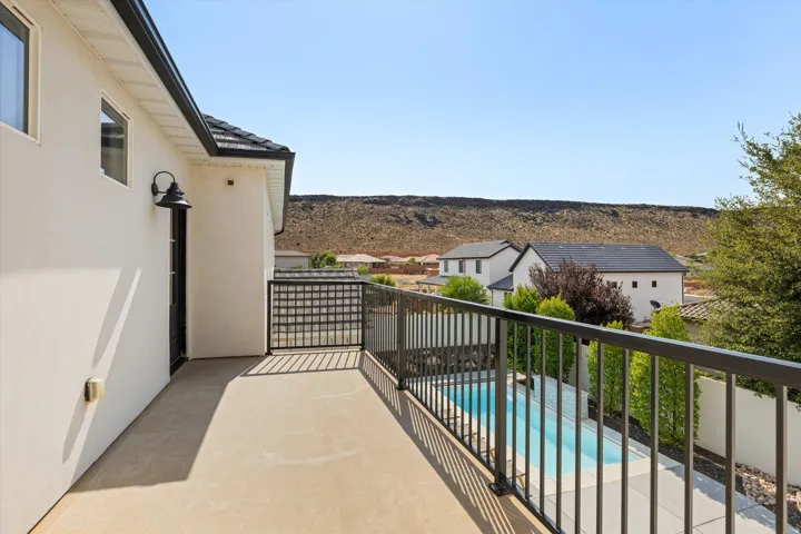 Elevated composite deck with metal railings overlooking resort-style swimming pool