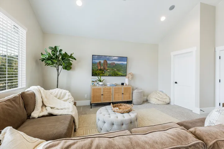 Bright, open living area featuring neutral wall finishes, recessed ceiling lighting, and large windows with plantation shutters