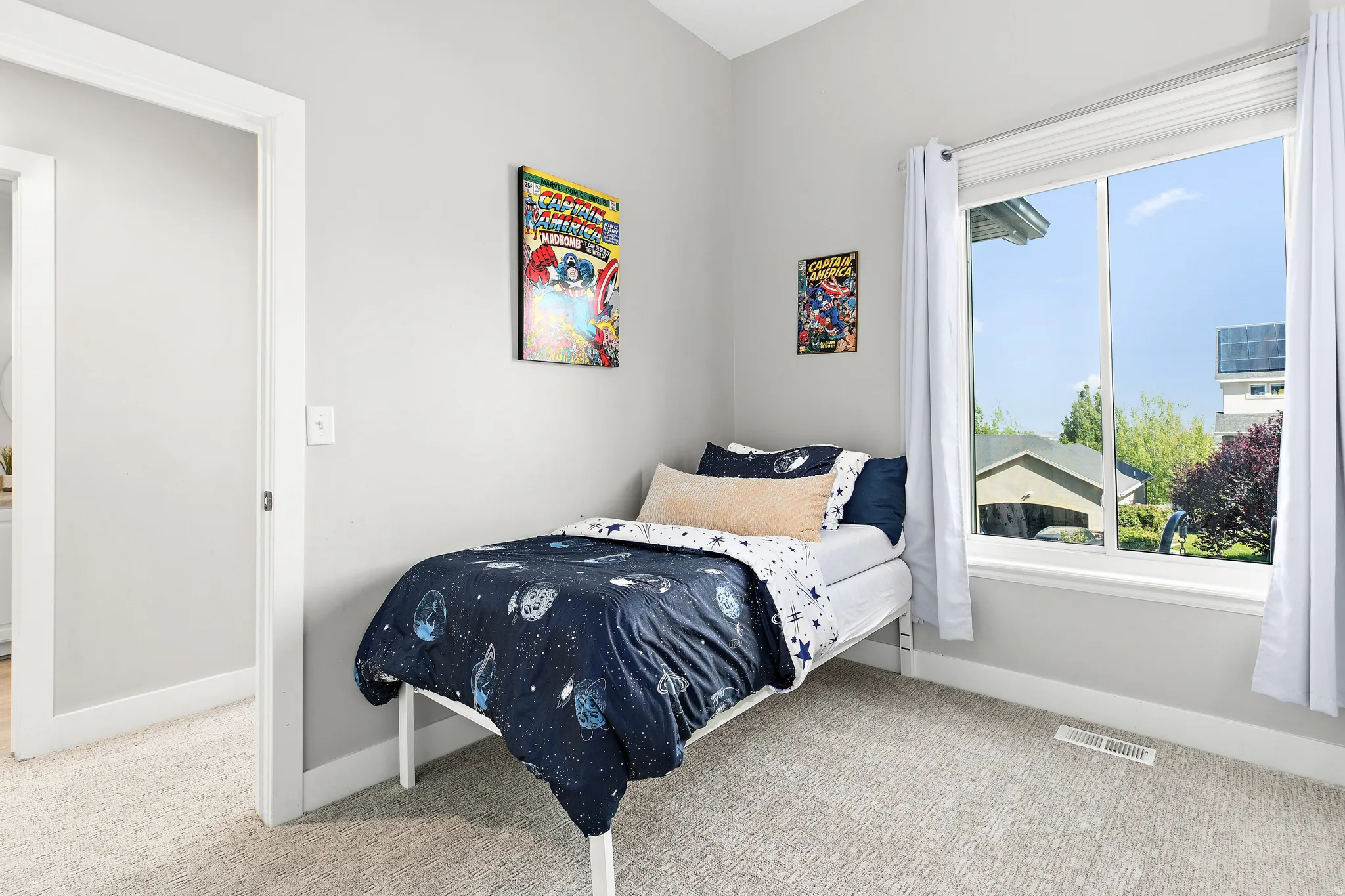 Light gray wall paint, textured carpeting, white window trim, and baseboards