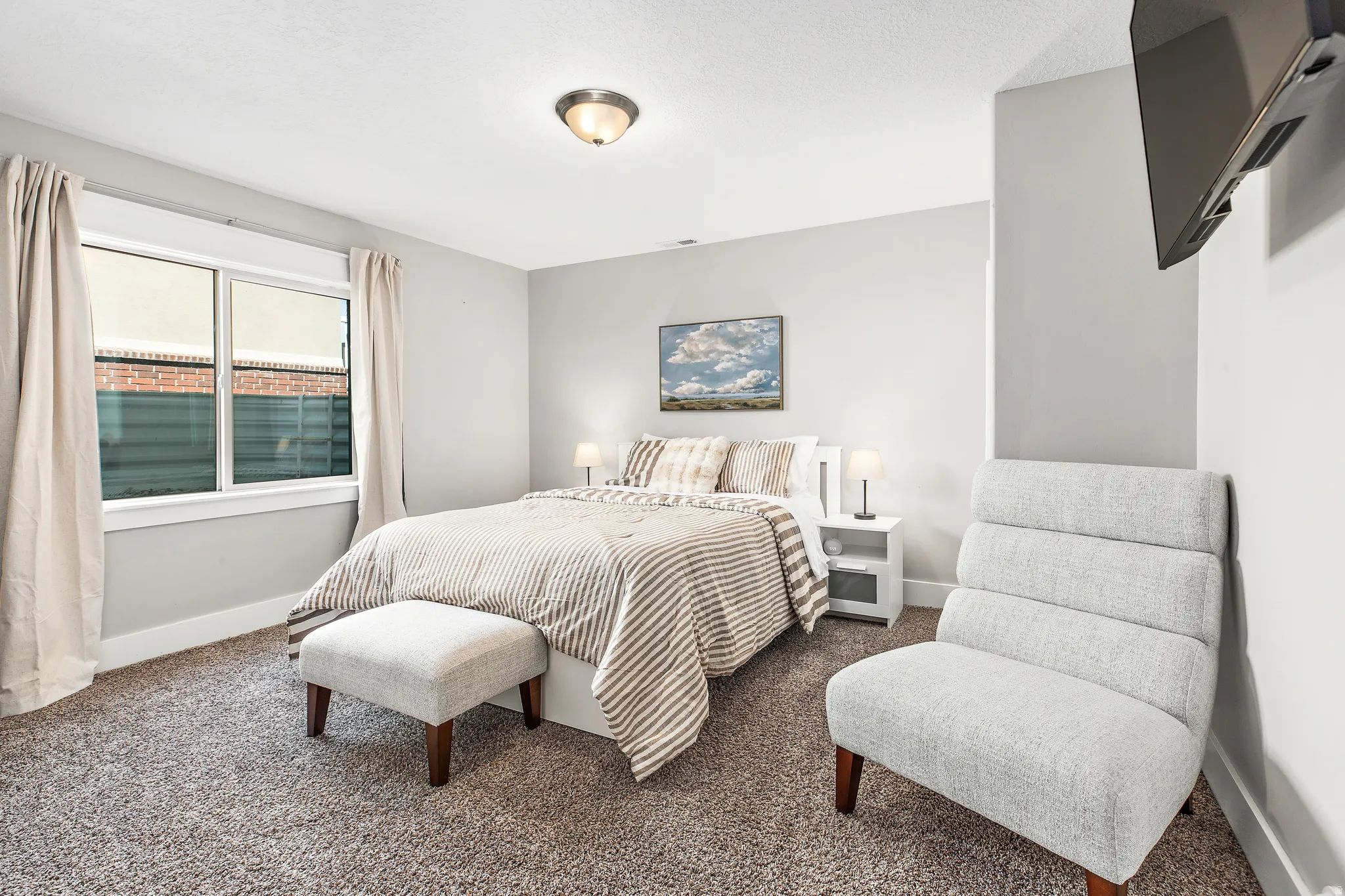 Recessed window with white trim, built-in wall-mounted television, and flush-mount ceiling light fixture