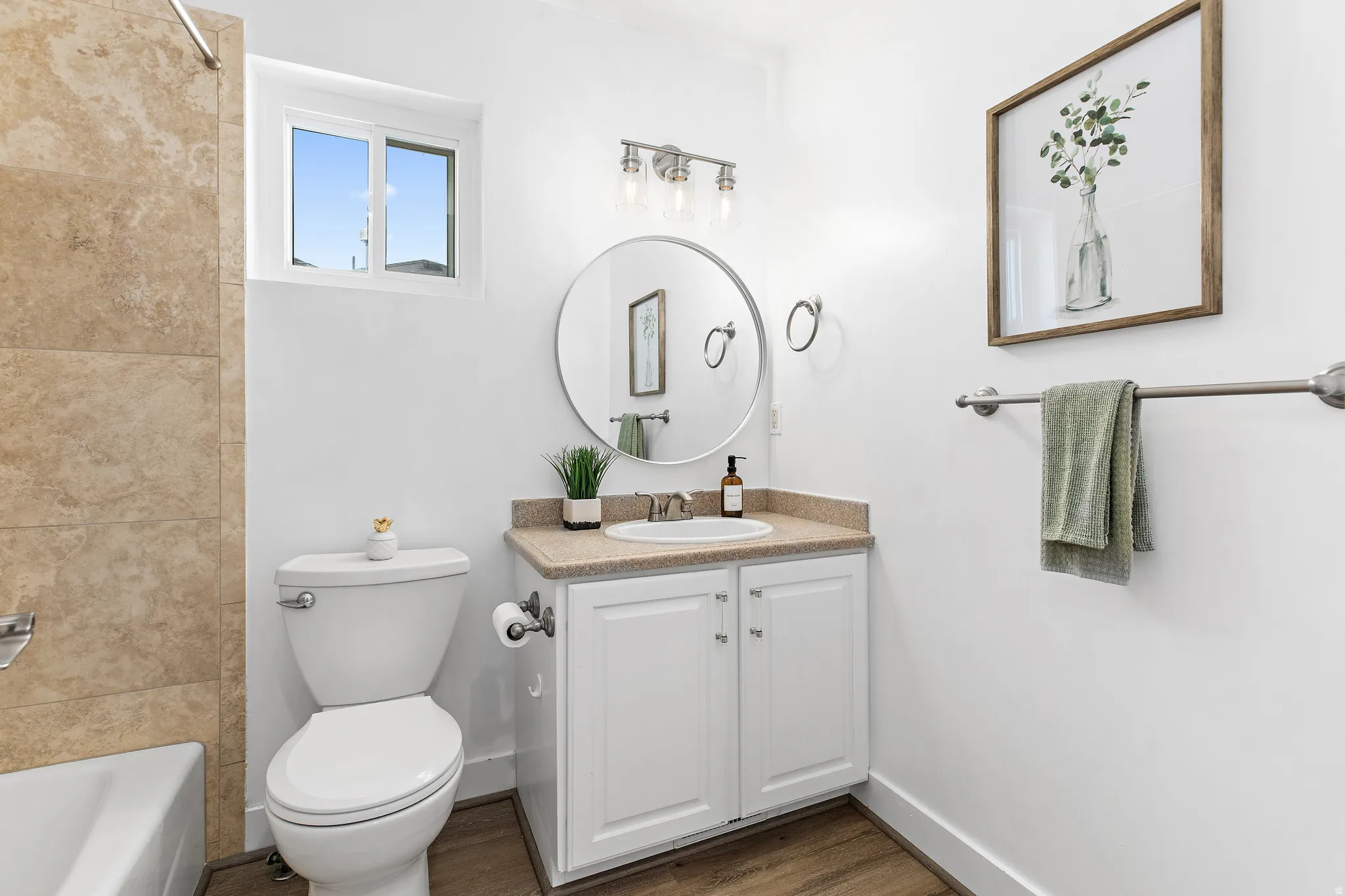 White vanity with a neutral-toned countertop and an undermount sink