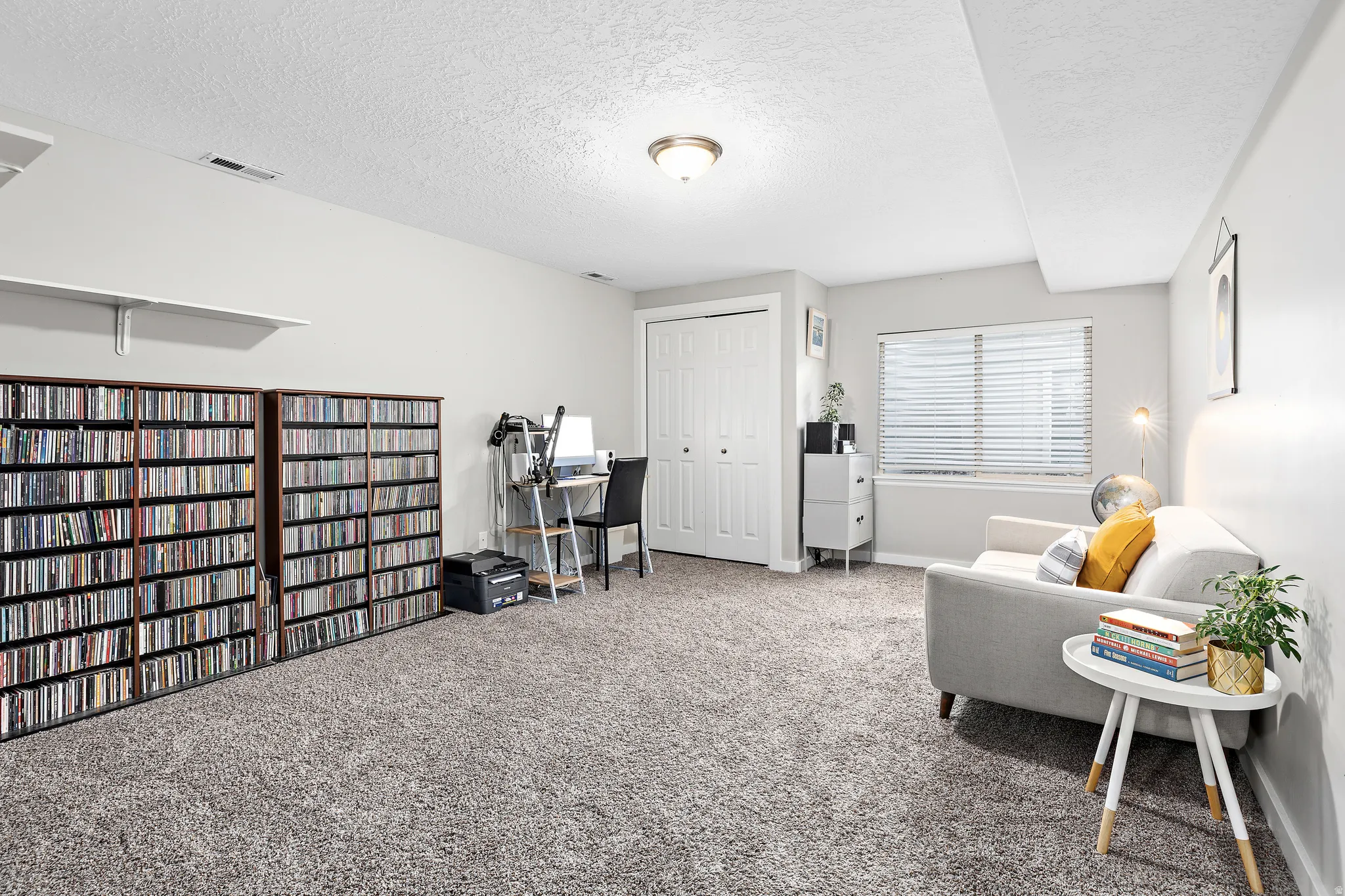 Wall-to-wall carpeting with light-toned walls and a window with blinds