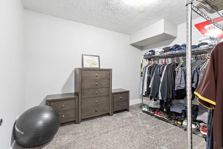 Carpeted flooring, white wall paint, and exposed ductwork