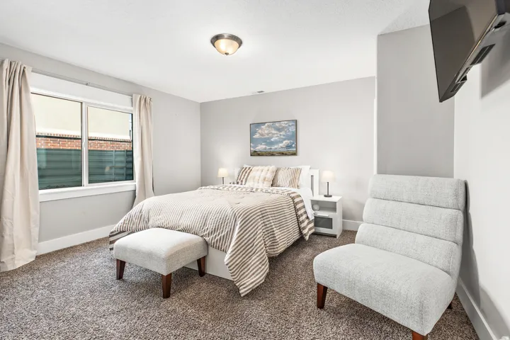 Recessed window with white trim, built-in wall-mounted television, and flush-mount ceiling light fixture