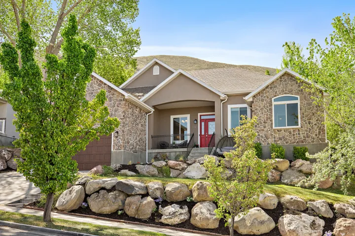 Stone and stucco exterior with a welcoming covered front porch and red accent door