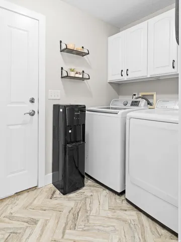 Herringbone-patterned wood-finish flooring, white shaker-style cabinetry, and wall-mounted shelving
