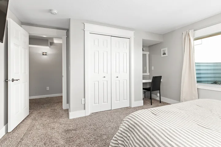 Plush carpeting, bi-fold closet doors, built-in desk area, recessed lighting, and a large window