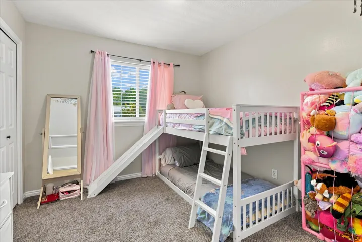 Window with horizontal blinds, neutral wall paint, and gray carpeted flooring