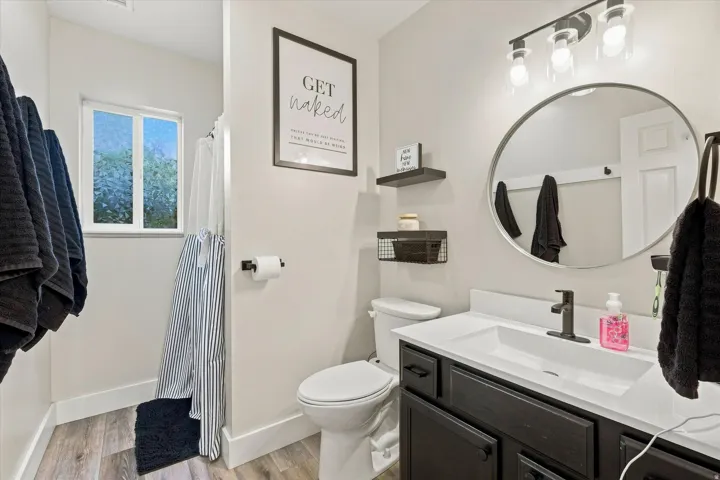 Bathroom featuring a single vanity with dark cabinetry, white countertop, and a rectangular undermount sink