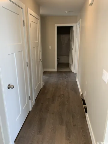 Wood-finish flooring, white paneled doors, and neutral wall tones