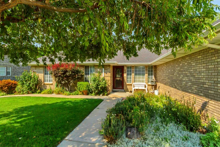 Brick exterior, gabled roof, front entry with transom window, landscaped front yard with mature plantings, concrete walkway