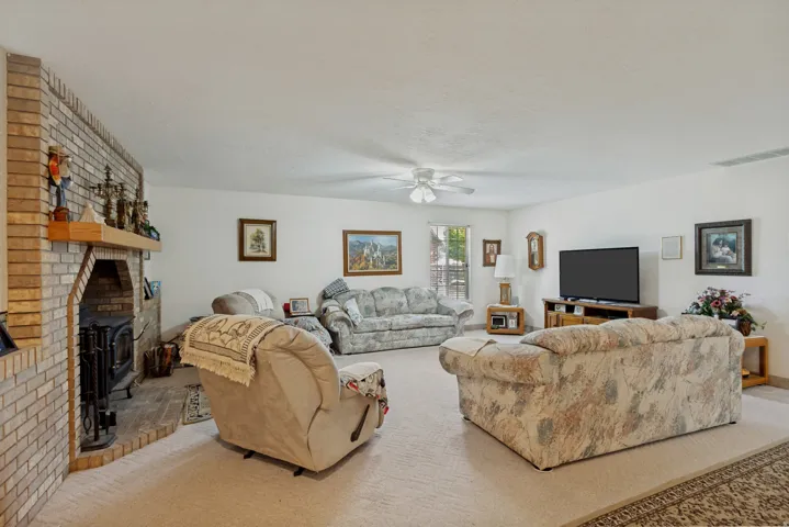 Brick fireplace with wood mantel, built-in hearth, and wood-burning stove insert