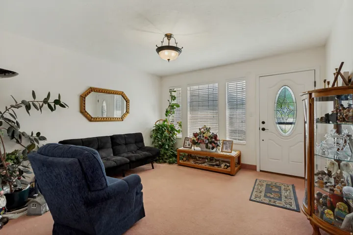 Bright sunroom with dual glass doors featuring decorative oval glass panels, plantation shutters, and abundant natural light