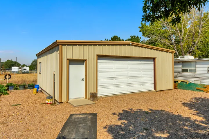 Metal utility building with a single garage door, a pedestrian door, and a single window