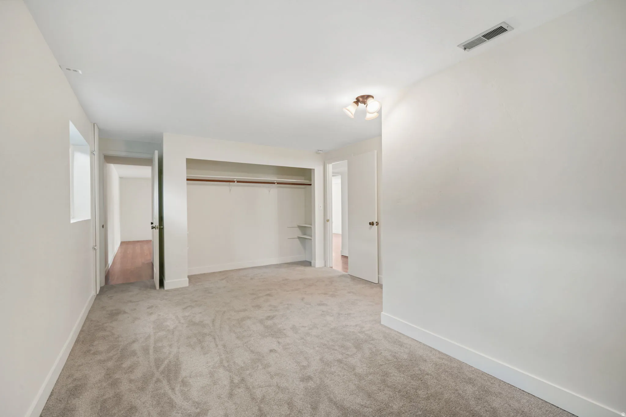 2nd basement bedroom, New Wall-to-wall carpeting, window, built-in closet with shelving, and ceiling-mounted light fixture