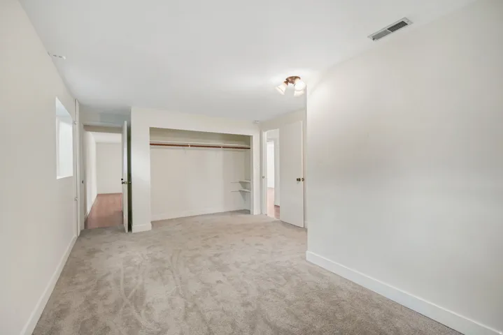 2nd basement bedroom, New Wall-to-wall carpeting, window, built-in closet with shelving, and ceiling-mounted light fixture